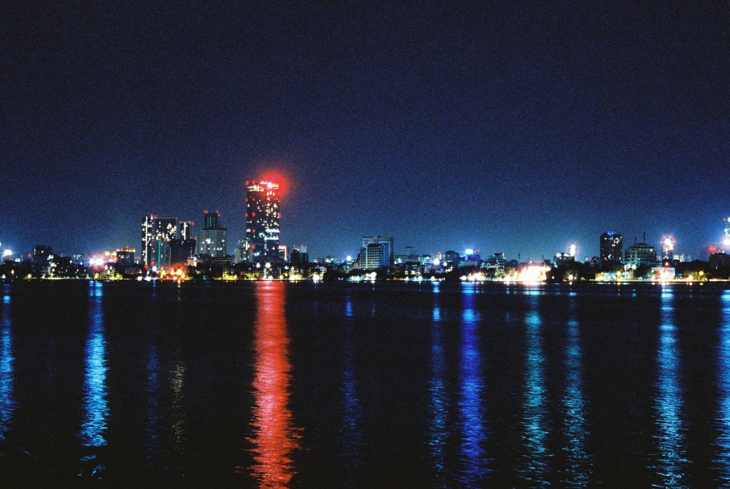 Hanoi skyline reflected across the water at night