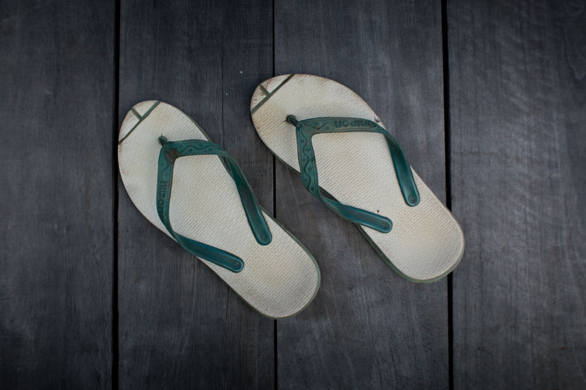 Real slippers arranged on dark wood